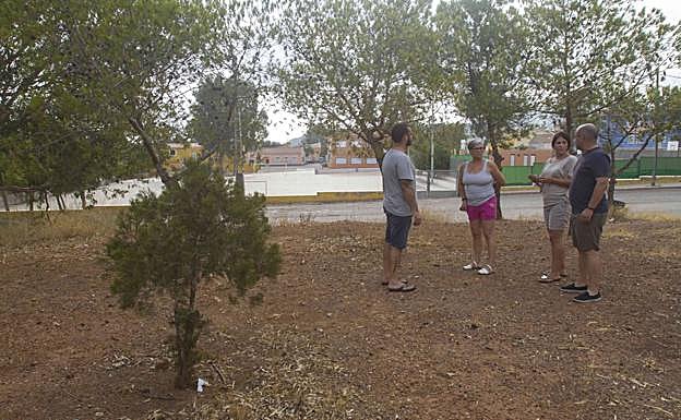 Vecinos de Llano del Beal, en la Balsa San Agustín, con el colegio al fondo. La foto es de 2018. 