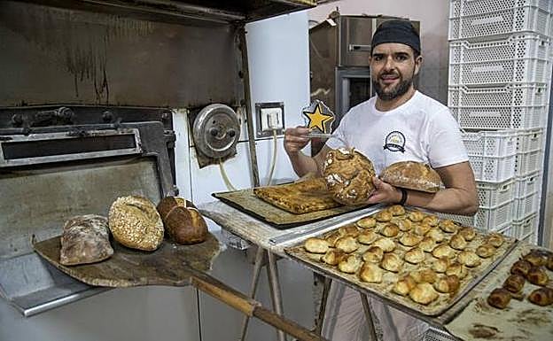 Pencho Otón, con el pan que elabora junto a su horno. 