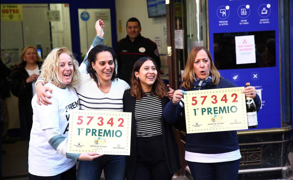 Un grupo de personas celebra en la administración de Lotería Doña Manolita haber dado parte del primer premio del sorteo del Niño.