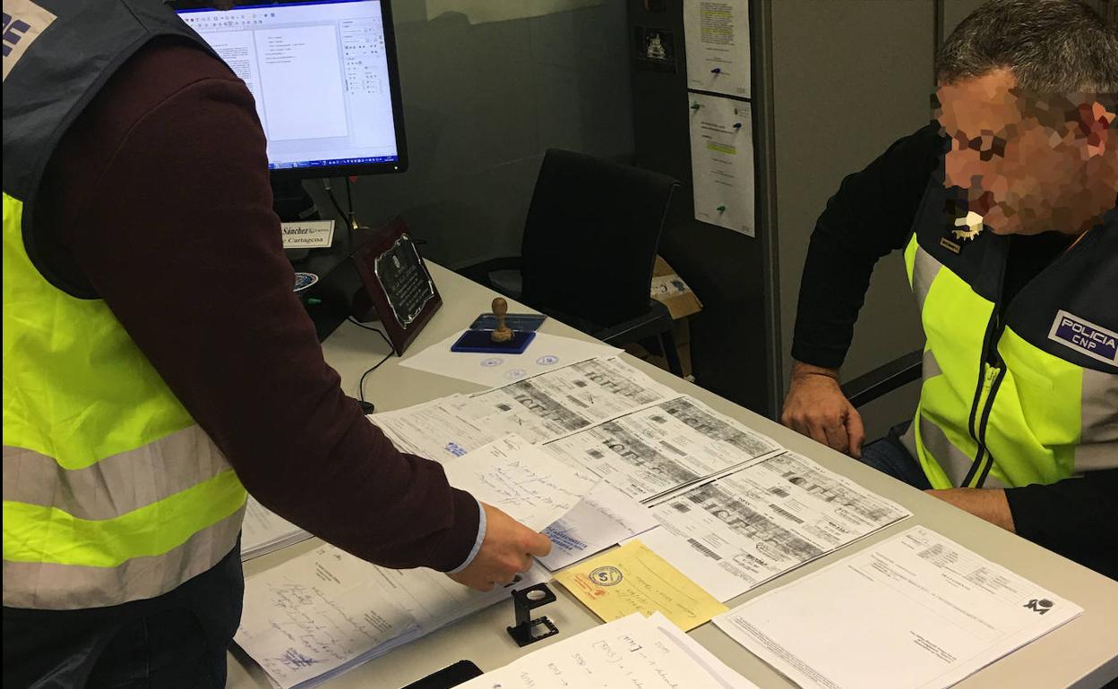 Dos agentes analizan las recetas falsificadas. 