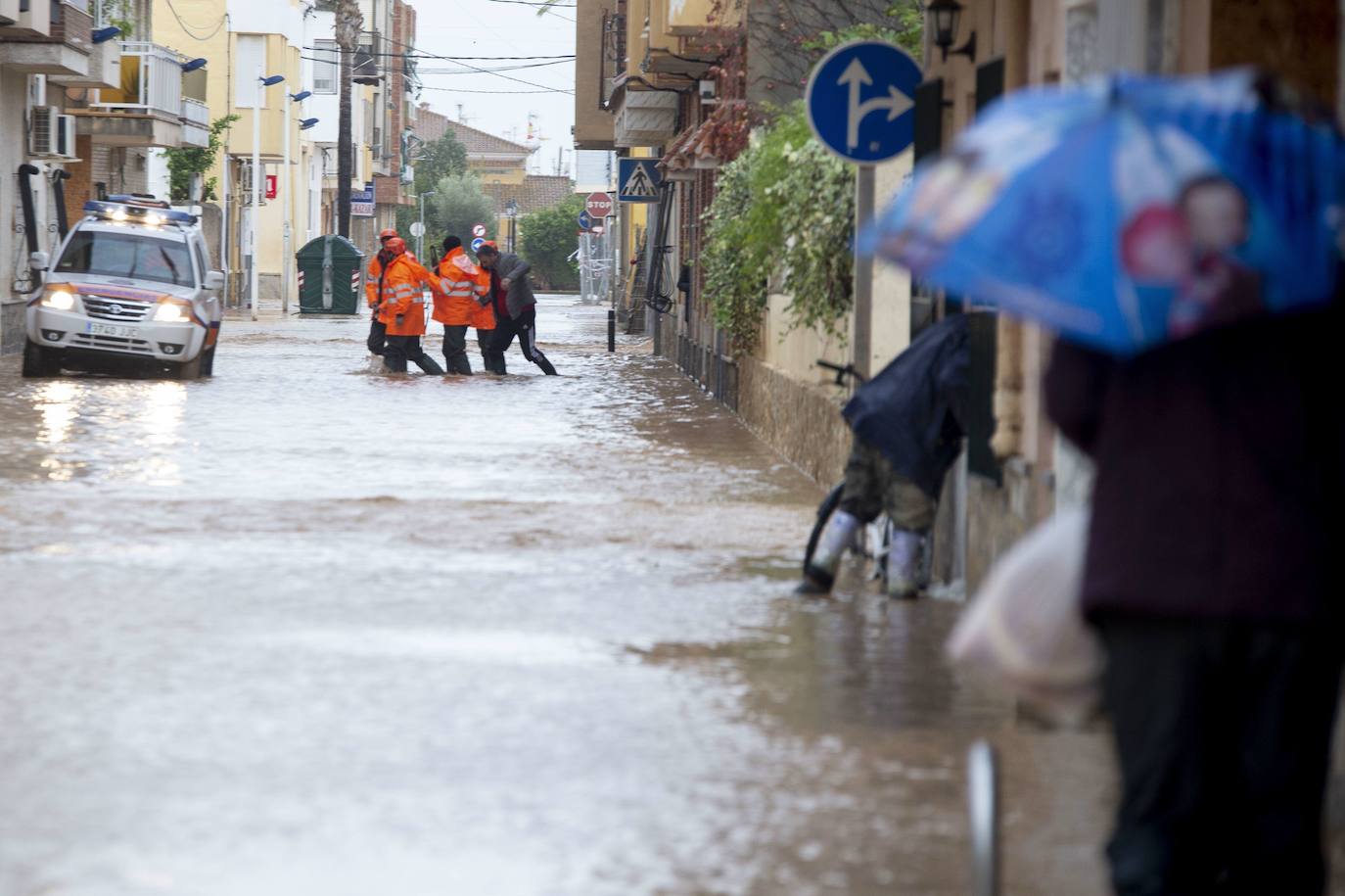03-12-2019. Riada de indignación en Los Alcázares. La tercera gran inundación en solo tres años satura la paciencia de unos vecinos atemorizados. Las riadas obligan de nuevo a desalojar a un centenar de vecinos, y dos carriles de la autovía RM-19 y una decena más de carreteras quedan cortadas en el entorno del Mar Menor. Las fuertes escorrentías de agua dulce y sedimentos hacen temer a los expertos una nueva anoxia. En la foto, efectivos de Protección Civil rescatan a un vecino en una de las calles de Los Alcázares, completamente anegada. :: Antonio Gil / AGM