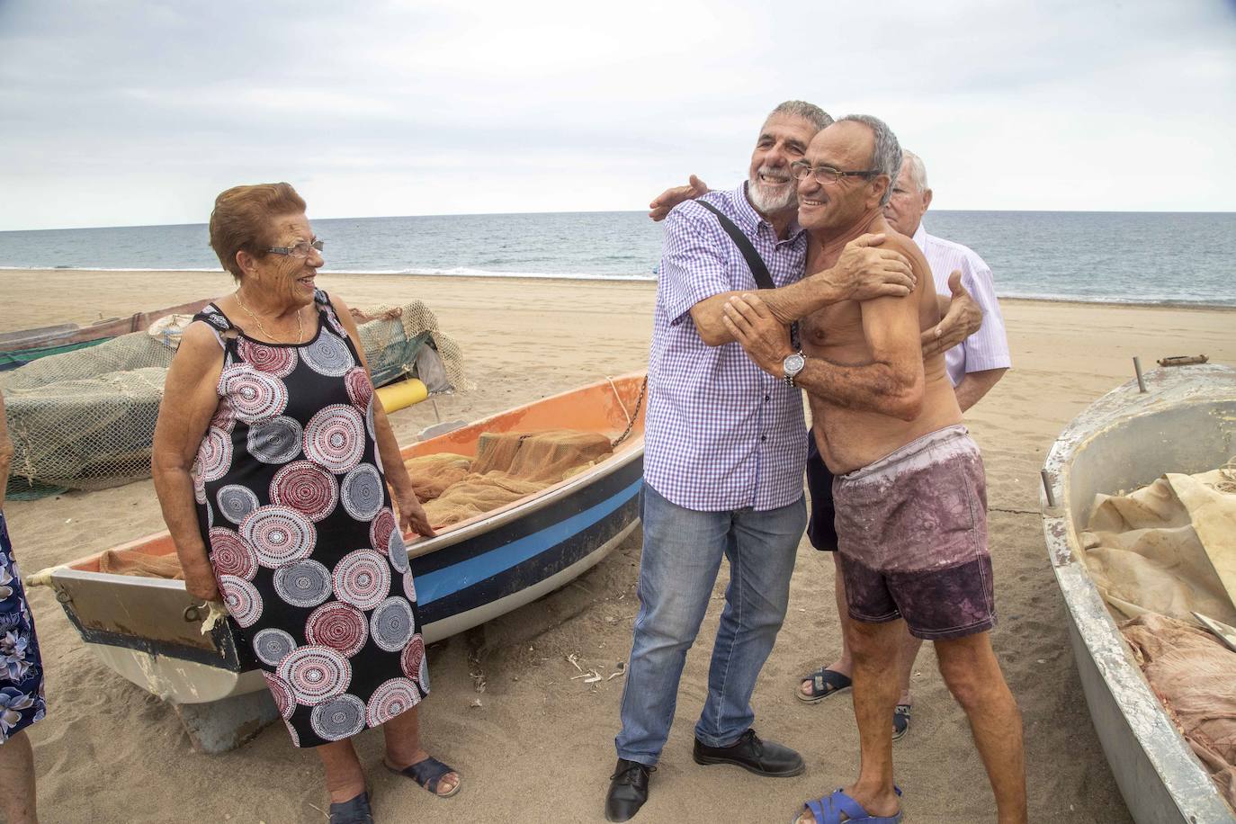 08-09-2019. El ‘ángel’ de la riada de Bolnuevo. El sacerdote Juan Pérez se reencuentra, treinta años después de la trágica riada de Bolnuevo, con el pescador que le salvó de morir ahogado. El capellán de La Arrixaca recuerda cómo la riada que desbordó la rambla de las Moreras le arrastró hasta el mar. Con él se encontraban una enfermera del hospital y su hijo de 9 años, que había acudido de visita. El niño sobrevivió con la ayuda del sacerdote, pero la mujer fue encontrada muerta en el lodo unos días después. En la foto, el sacerdote, con camisa de cuadros, y el pescador Pedro Rocha, abrazados en Bolnuevo. :: Pablo Sánchez / AGM