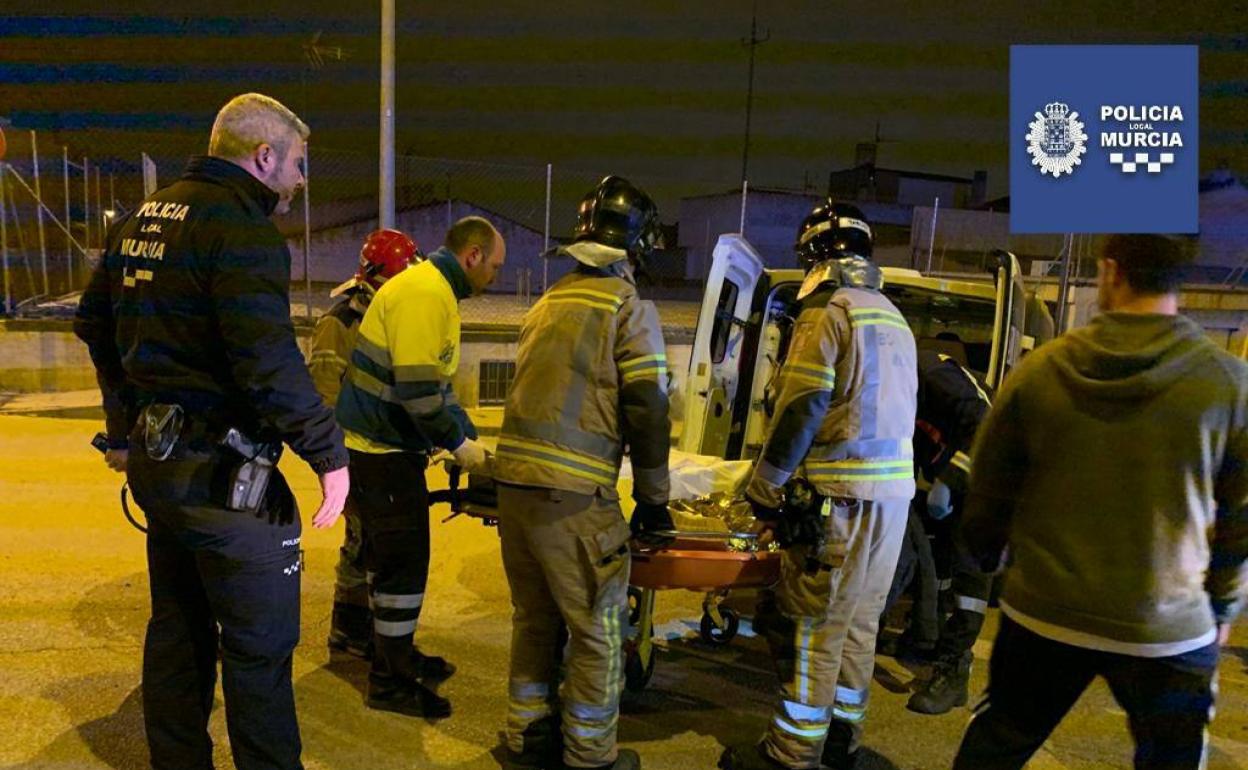 Agentes de la Policía Local y efectivos de bomberos trasladan al joven.