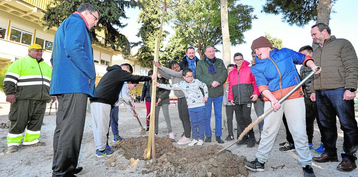 El alcalde, José Ballesta, junto a varios escolares del colegio Juan Carlos I de Llano de Brujas, en la plantación. 