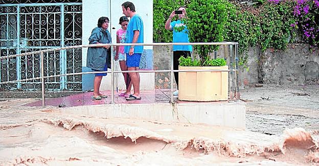 Unos vecinos, en septiembre, mientras observaban la rambla de Churra, desbordada por la DANA. 