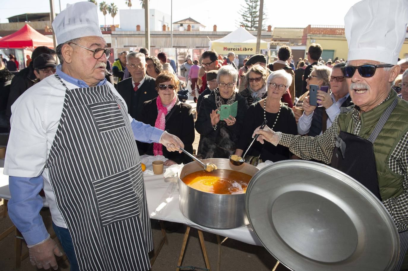 Decenas de personas se agolpan junto a las barras, donde amas de casa y peñistas sirven las típicas pelotas galileas