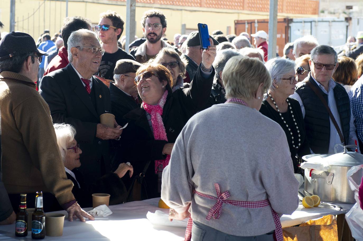 Decenas de personas se agolpan junto a las barras, donde amas de casa y peñistas sirven las típicas pelotas galileas