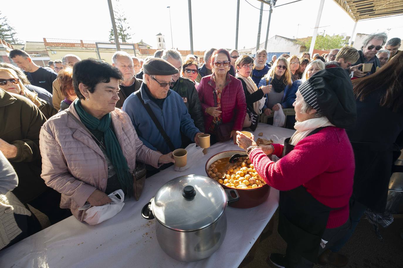 Decenas de personas se agolpan junto a las barras, donde amas de casa y peñistas sirven las típicas pelotas galileas