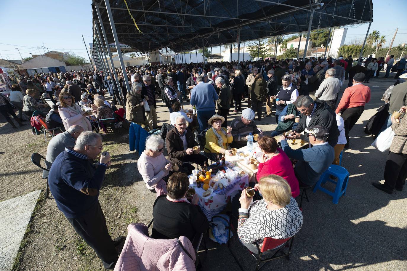 Decenas de personas se agolpan junto a las barras, donde amas de casa y peñistas sirven las típicas pelotas galileas