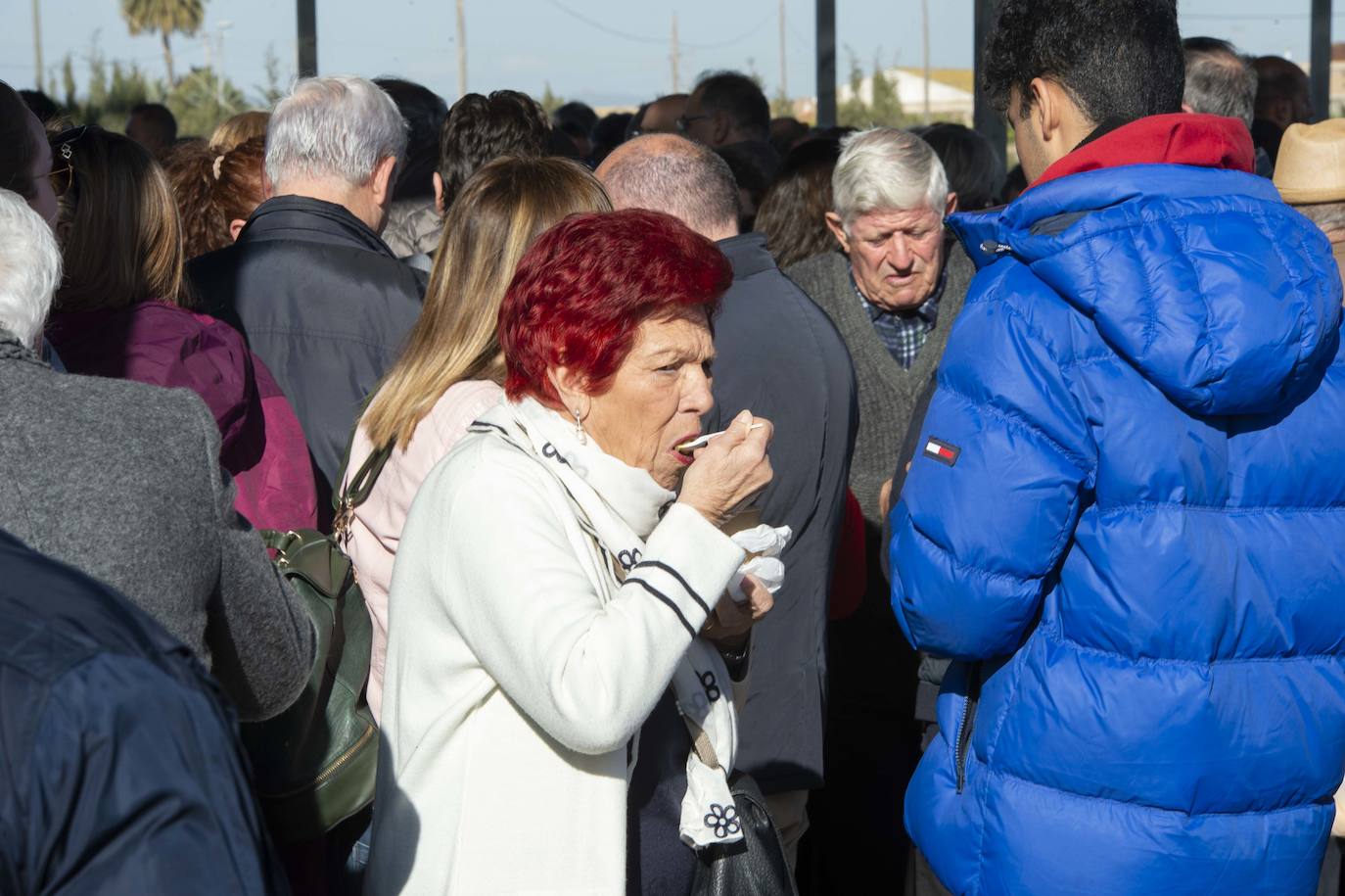 Decenas de personas se agolpan junto a las barras, donde amas de casa y peñistas sirven las típicas pelotas galileas