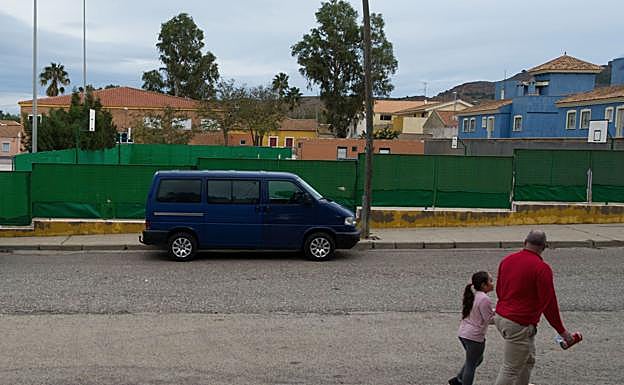 Un hombre y una niña pasan ante el colegio público del Llano, en una imagen tomada en noviembre de 2018. 