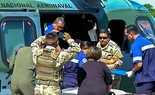 Las fuerzas de seguridad trasladan a una de las personas rescatadas. 