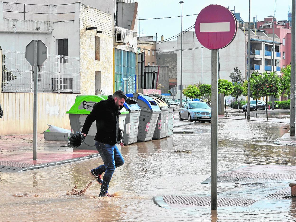 Un joven trata de atravesar una calle completamente inundada en Espinardo. 