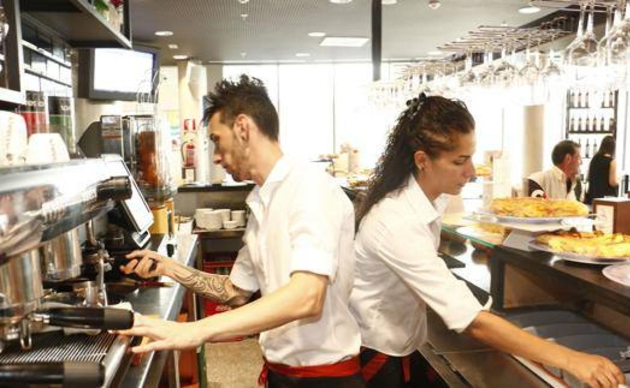 Dos jóvenes trabajando en un bar, en una imagen de archivo.