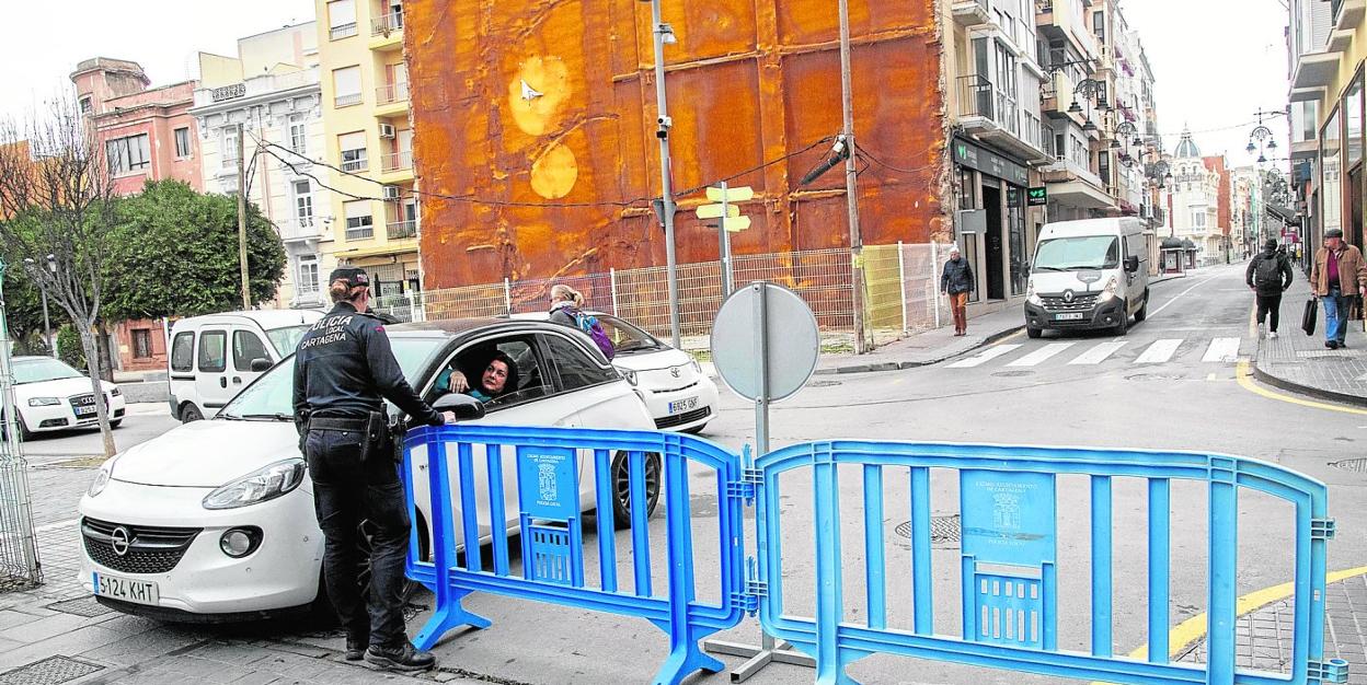 Un agente de la Policía Local informa a un automovilista del corte de tráfico para vehículos no autorizados, en la calle del Duque. 