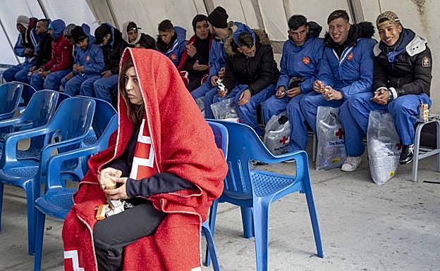 Una argelina llegada en patera toma un café con leche en un puesto de Cruz Roja en el puerto de Cartagena.
