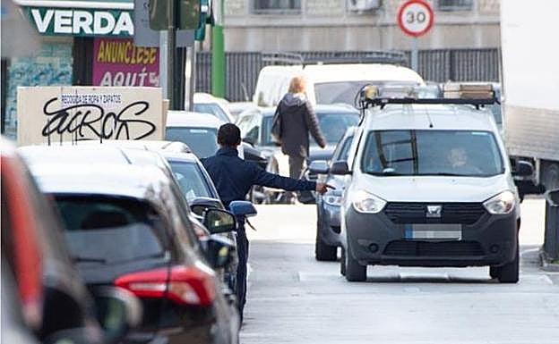 Un gorrilla señala un aparcamiento a un condcutor en la avenida Río Segura de Murcia. 