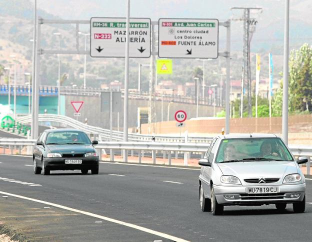 Dos coches circulan por el Eje Transversal, durante su apertura en el año 2006.