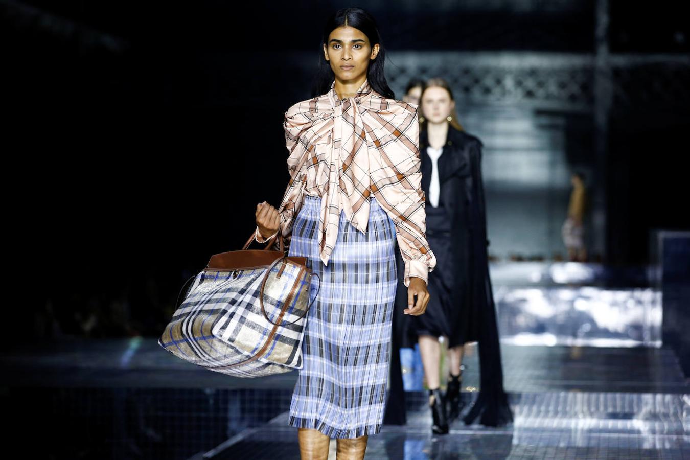 Burberry reinventa su mítico estampado de cuadros y lo traslada a botines, vestidos camiseros, chaquetones y pantalones. Además en la pasarela de Londres presenta su nuevo concepto de camisa con triple cuello que se transforma en hombrera.