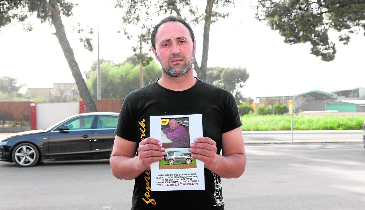 Juan Francisco sostiene uno de los carteles con la foto de su padre, que distribuye los domingos por los pueblos de Almería. 