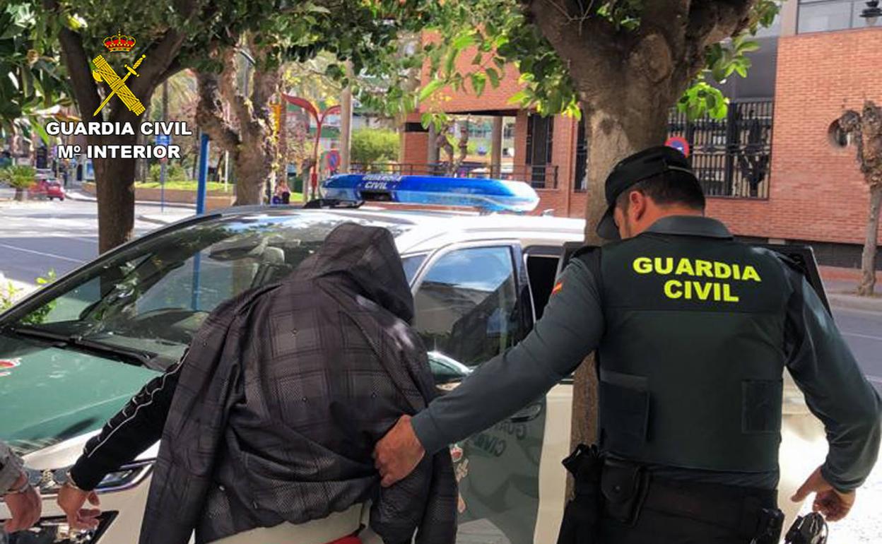 Un agente de la Guardia Civil escolta a uno de los detenidos.