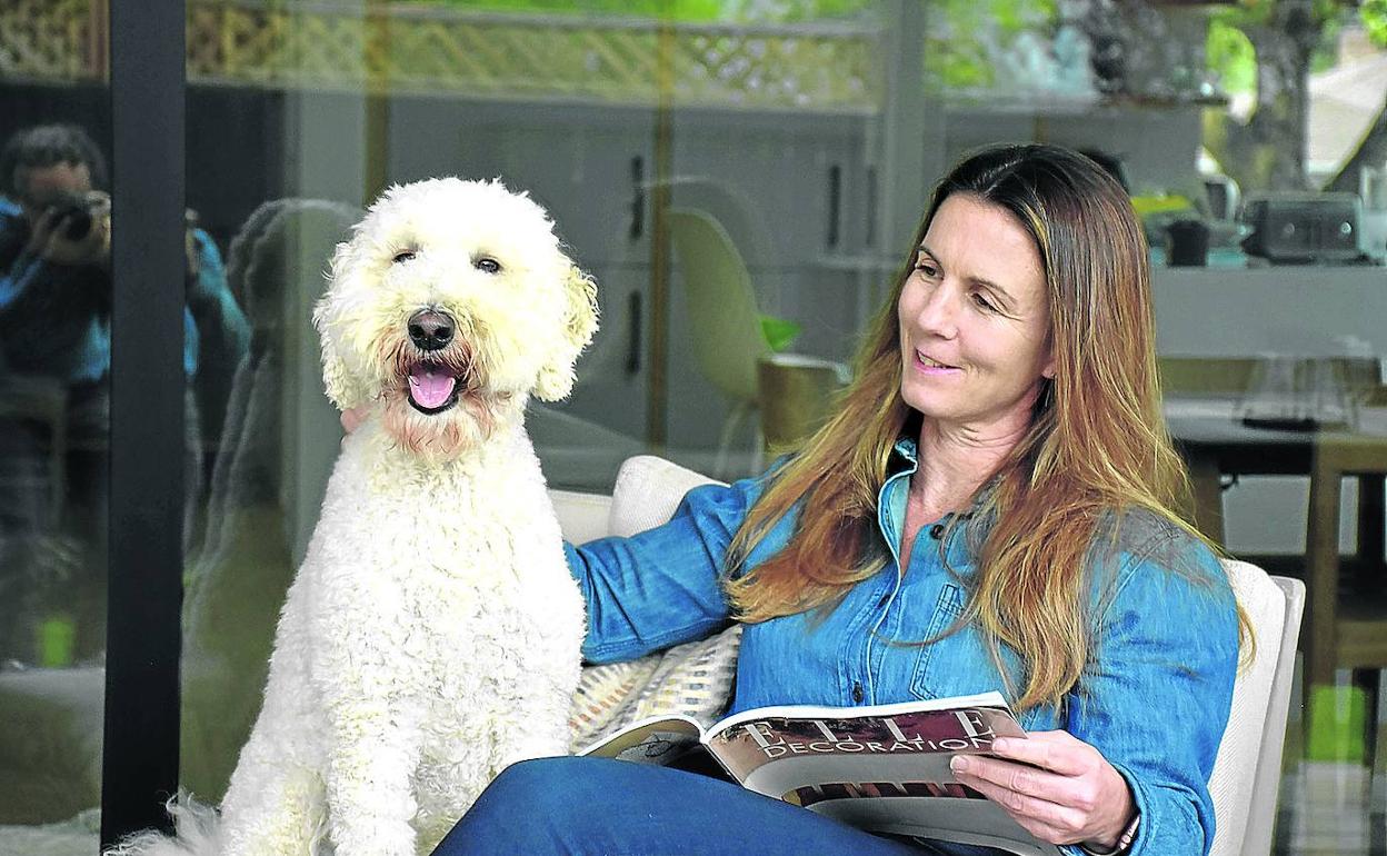 La ejecutiva ojea revistas de decoración y arquitectura acompañada de su perro, Cooper, en su casa de Palo Alto, California.