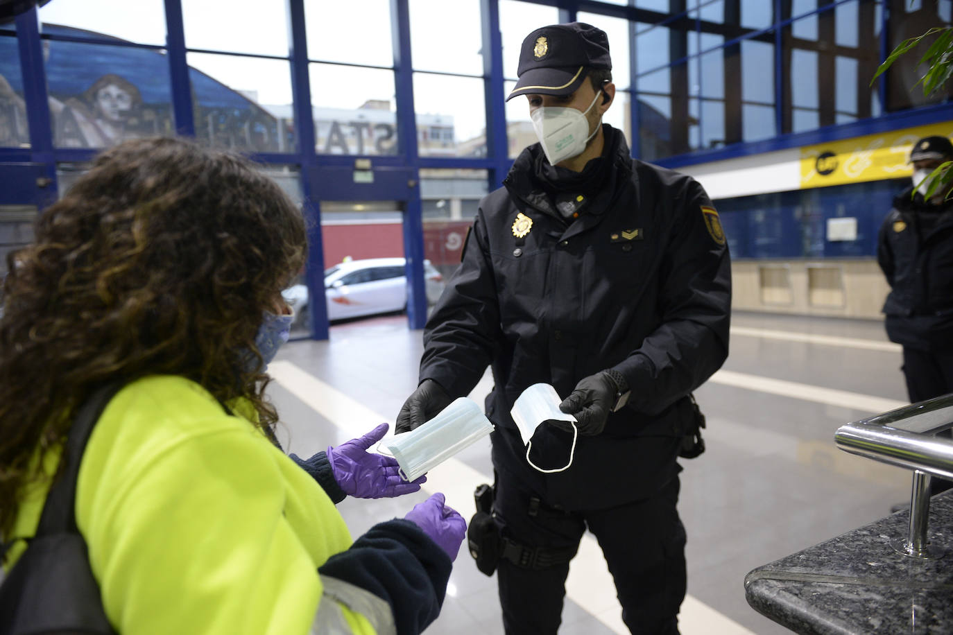 La Policía Nacional dispensa mascarillas en la estación de autobuses de Murcia.