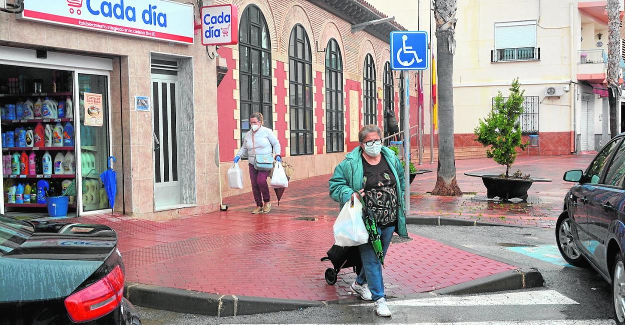 Dos vecinas de Campos del Río caminan por una calle con sus bolsas después de hacer la compra, ayer. 