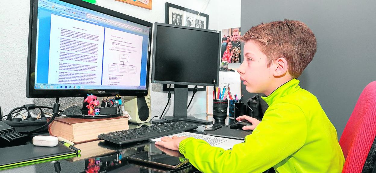 Un alumno realiza los trabajos que le han puesto sus profesores conectado con el ordenador desde su vivienda. 