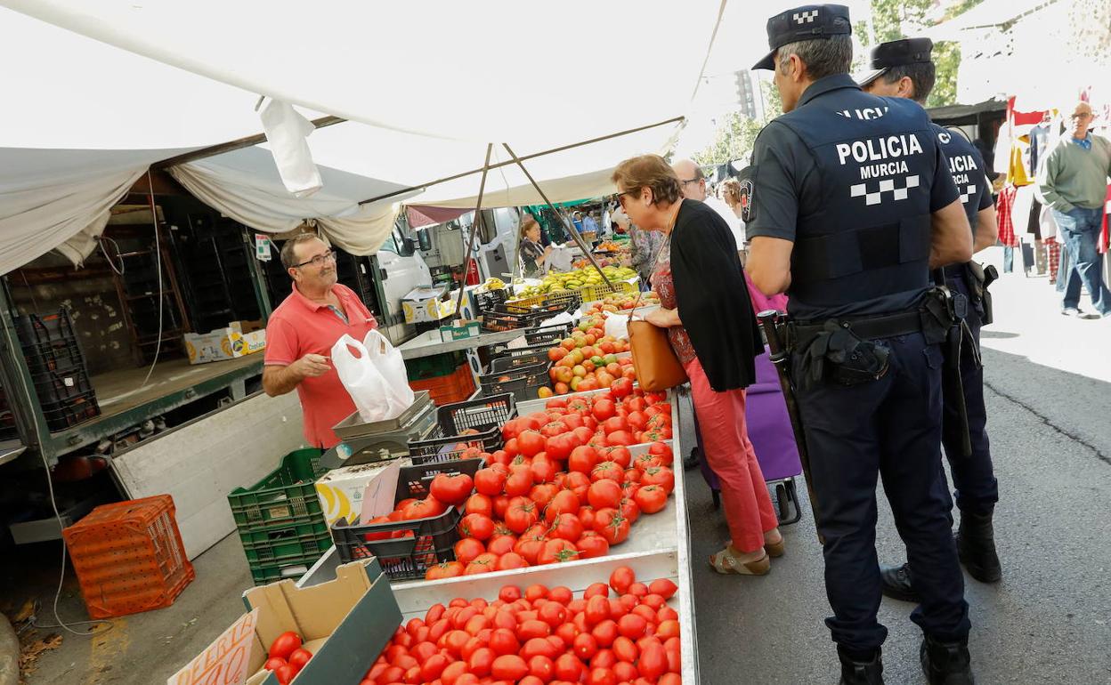 Agentes de la Policía Local de Murcia en un puesto del mercado semanal de La Fama.