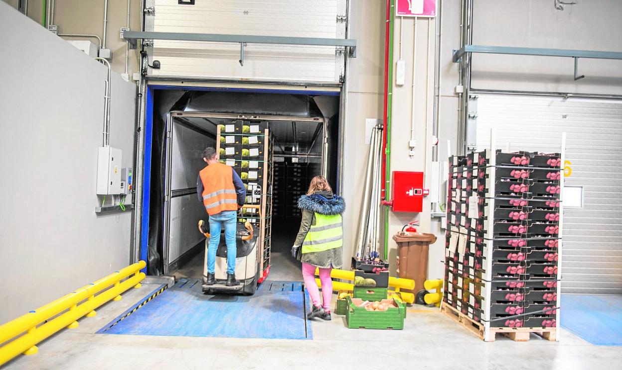 Dos trabajadores cargan frutas y hortalizas en un camión, ayer tarde, en la sede logística de Primafrio en Alhama de Murcia. 
