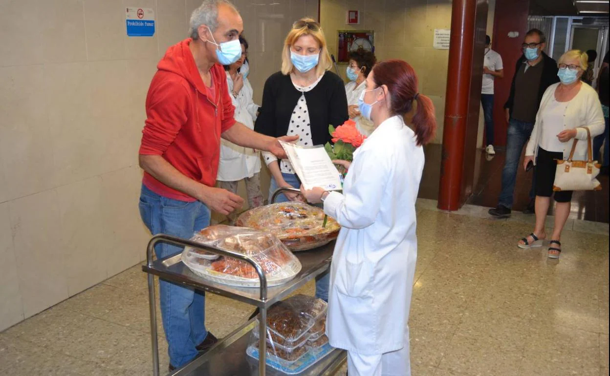 Un refugiado rifeño entrega comida y dulces típicos del Ramadán a una sanitaria del hospital Virgen de la Arrixaca, el pasado jueves.