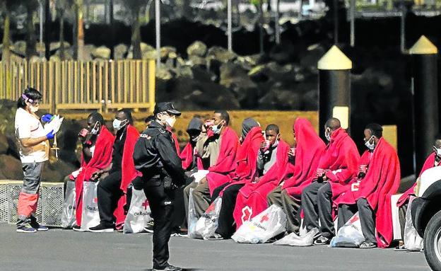 Imagen principal - 35 inmigrantes llegados a Puerto del Rosario, en Fuerteventura, a finales del pasado abril reciben asistencia de Cruz Roja. | Un sanitario atiende a un bebé nacido durante la travesía mientras una mujer rescatada por un velero llega a Mogán tras diez días de travesía.