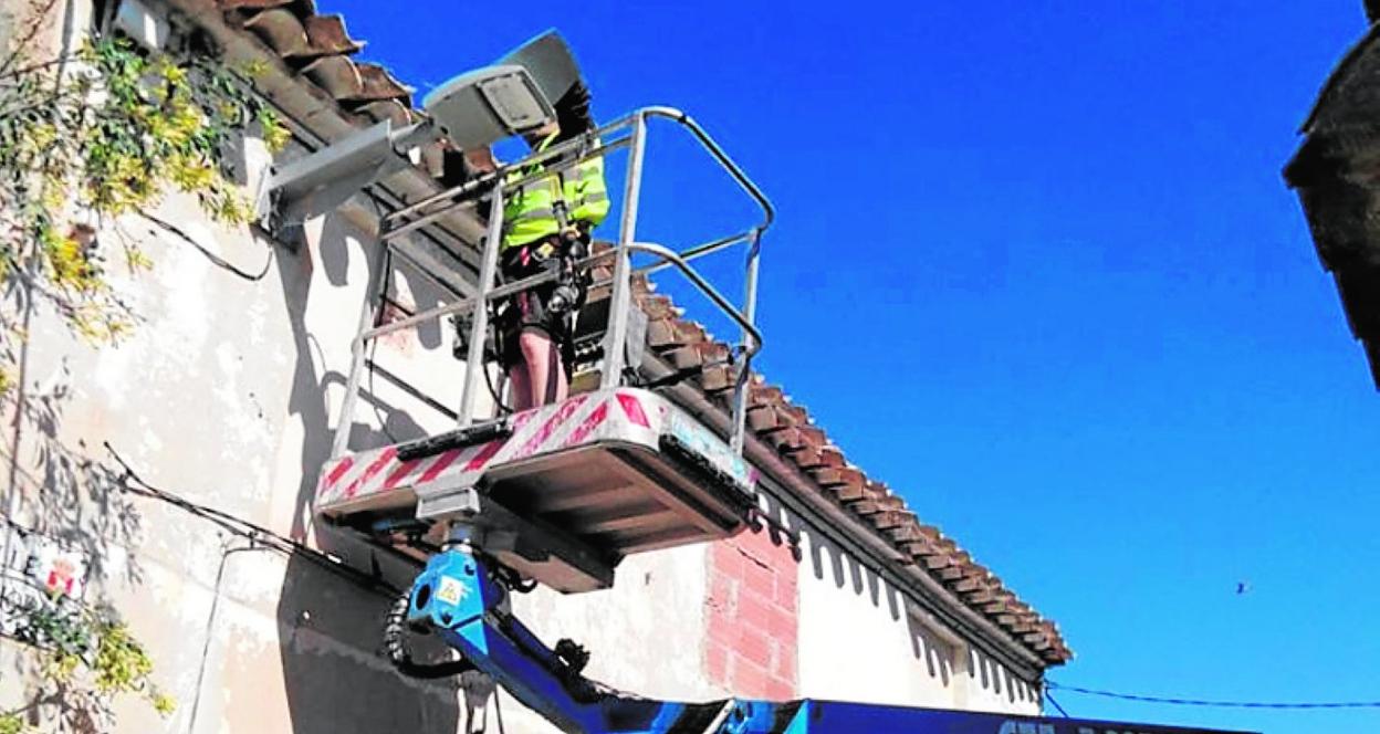 Un operario instala una de las nuevas luminarias, en Campos del Río. 