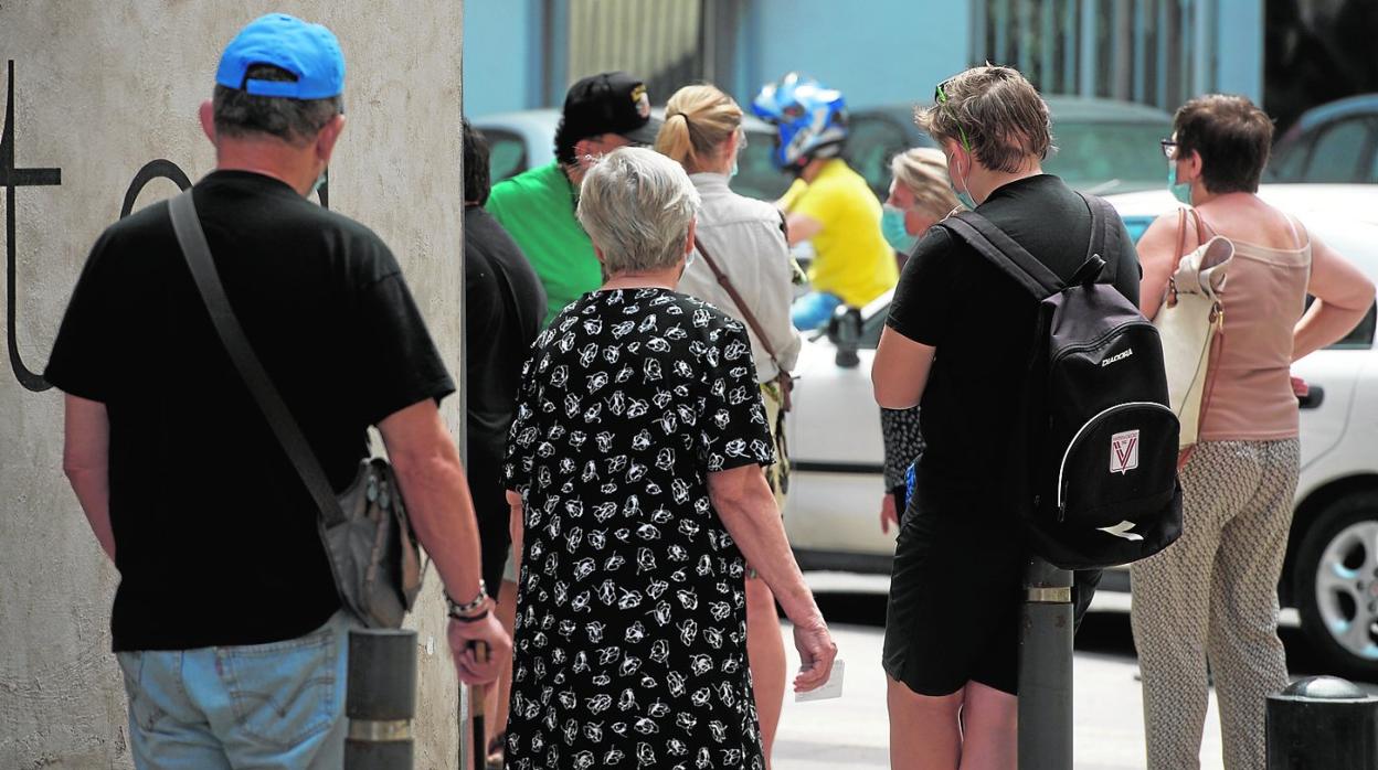 Un grupo de personas hacen cola para poder ser atendidas en las instalaciones de Jesús Abandonado, en Murcia. 