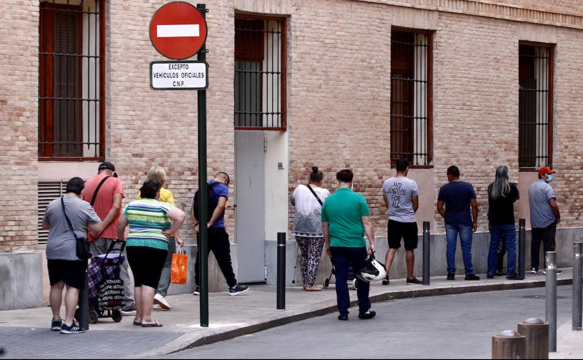 Varias personas hacen la cola para recoger alimentos en Jesús Abandonado, este viernes en Murcia.