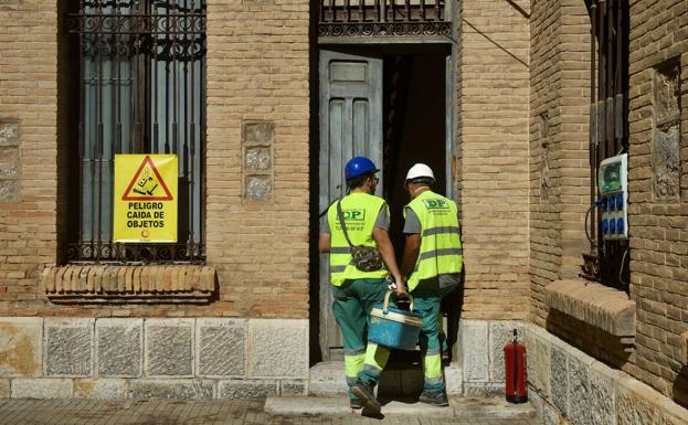 Obreros accediendo al edificio para comenzar las obras.