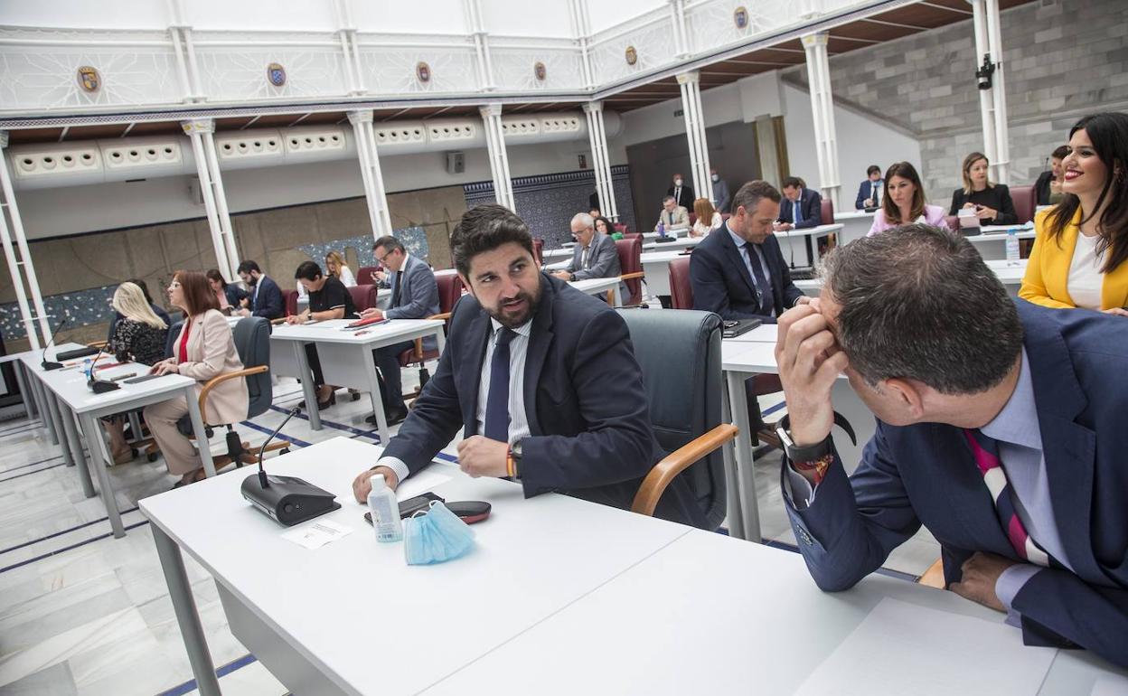 López Miras habla con el consejero Celdrán al inicio de la sesión en la Asamblea.