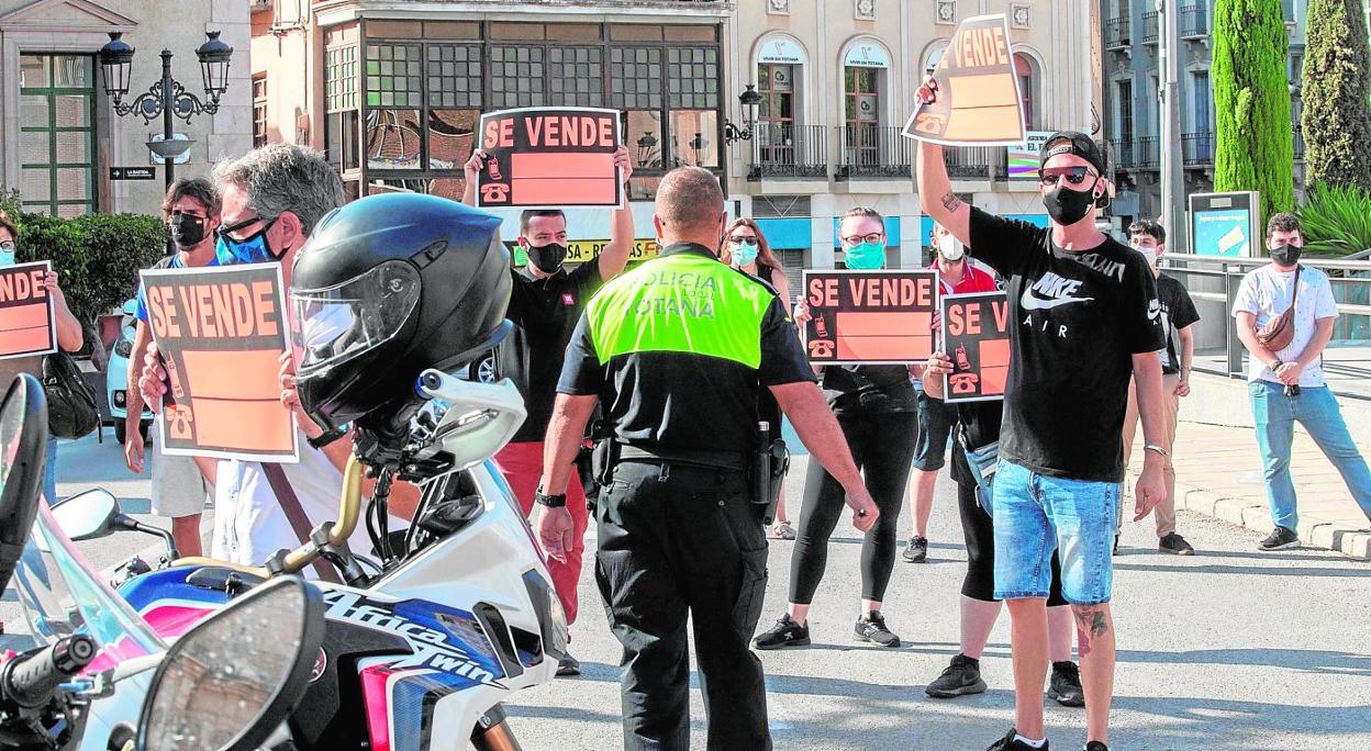 Hosteleros de Totana protestando, ayer, con carteles alusivos al cierre y traspaso de sus negocios, tras conocer el retorno del municipio a la Fase 1 de confinamiento. 