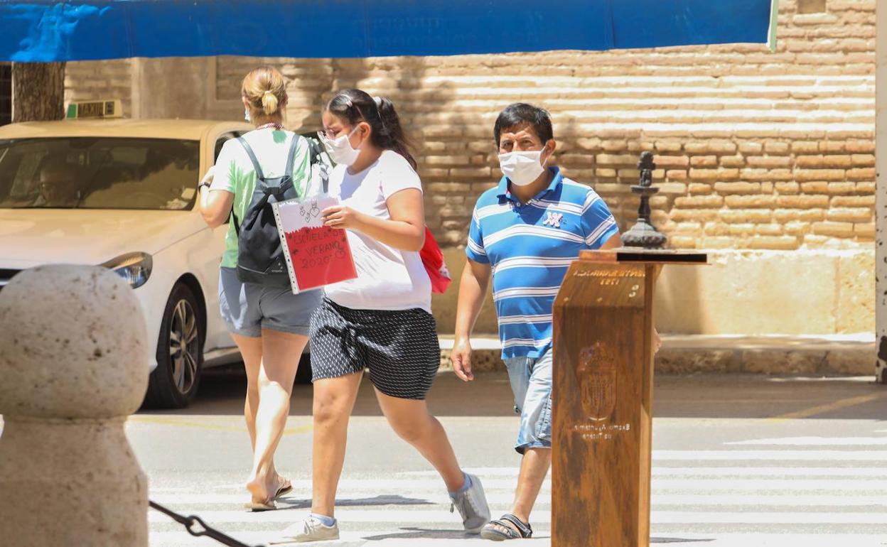 Una mujer y un hombre pasean por Totana con mascarilla.