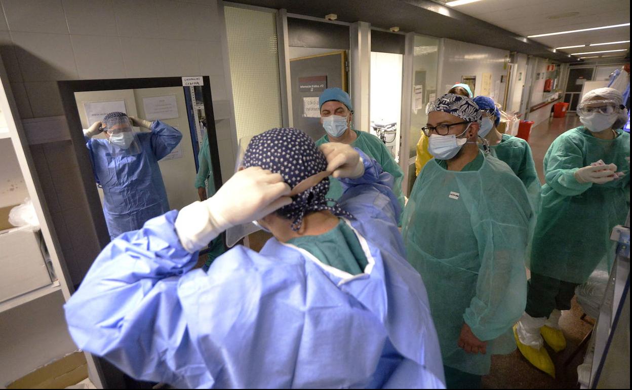 Sanitarios del hospital Virgen de la Arrixaca se equipan con la indumentaria de protección.