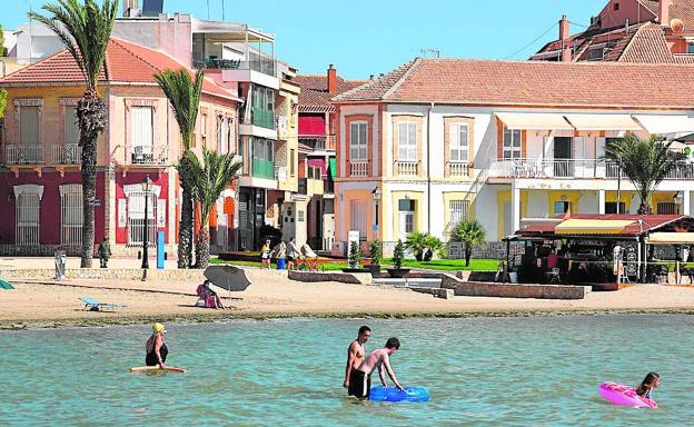 Varios bañistas disfrutan de la tranquila playa Carrión, en Los Alcázares. 