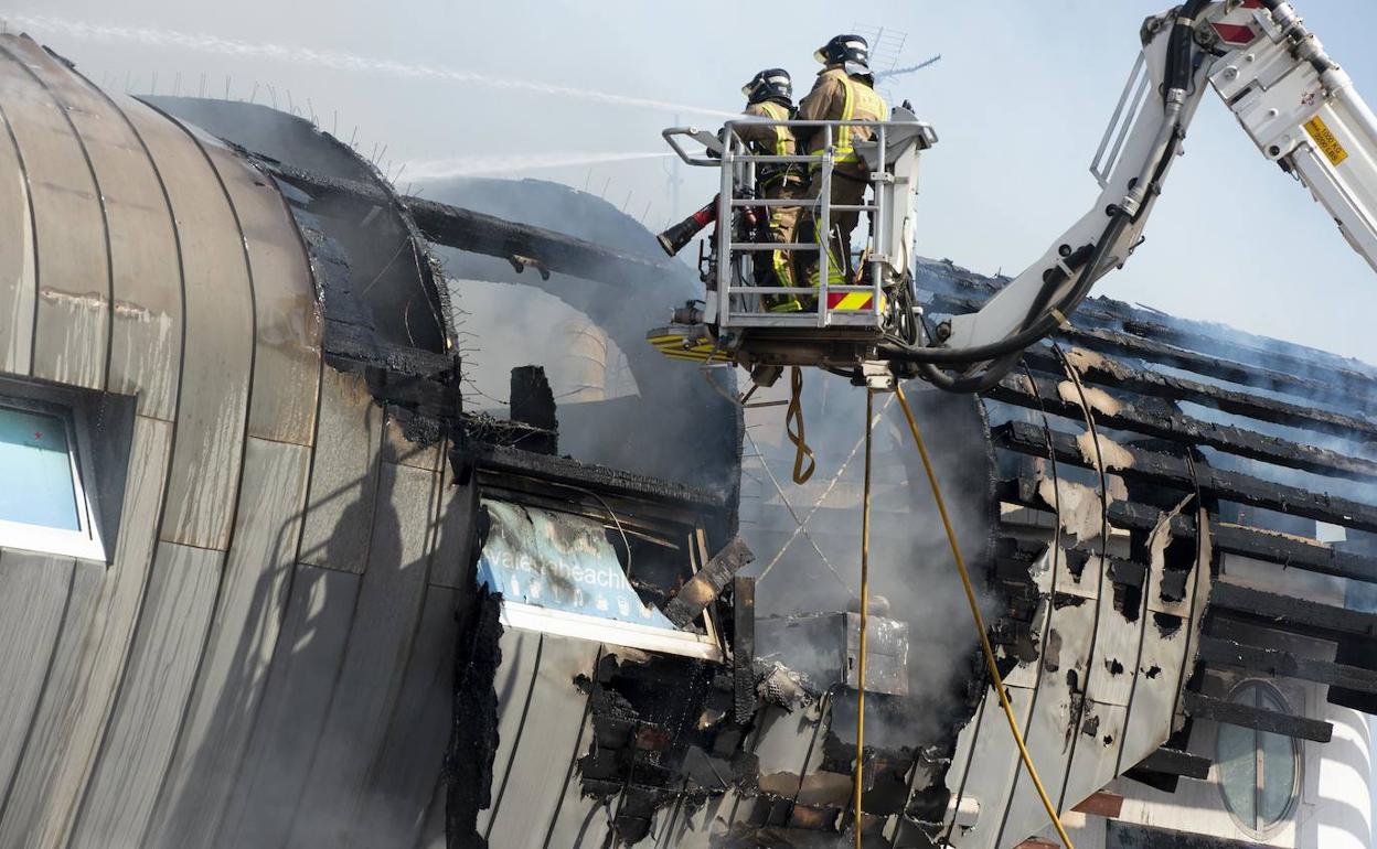 Trabajos de extinción sobre la techumbre del edificio.