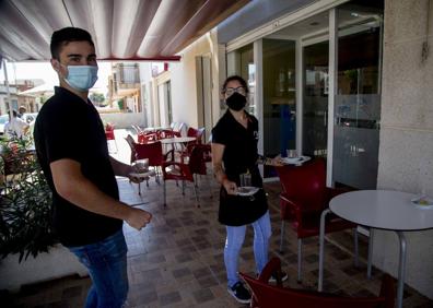 Imagen secundaria 1 - 1- Joaquín Gallego y Aida Castejón recogen una mesa en la cafetería Pedregal. 2- Sofía Marín, con una bandeja de magdalenas, en la panadería Pedregal.
