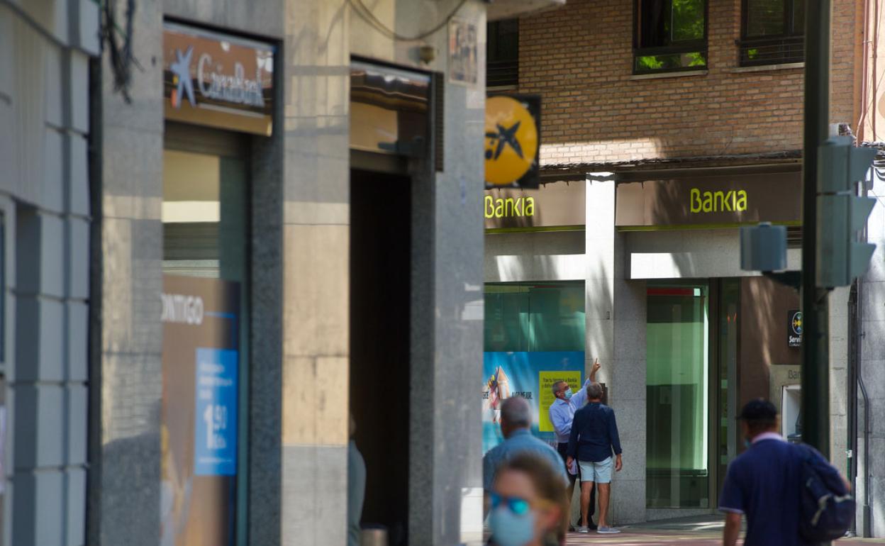 Una sucursal de CaixaBank y otra de Bankia, frente a frente en el centro de Murcia. 