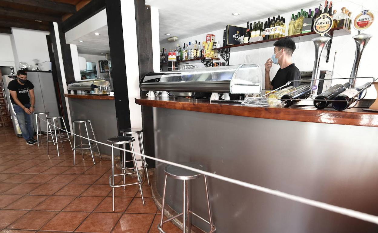 Un hostelero precinta la barra de un restaurante de Murcia.