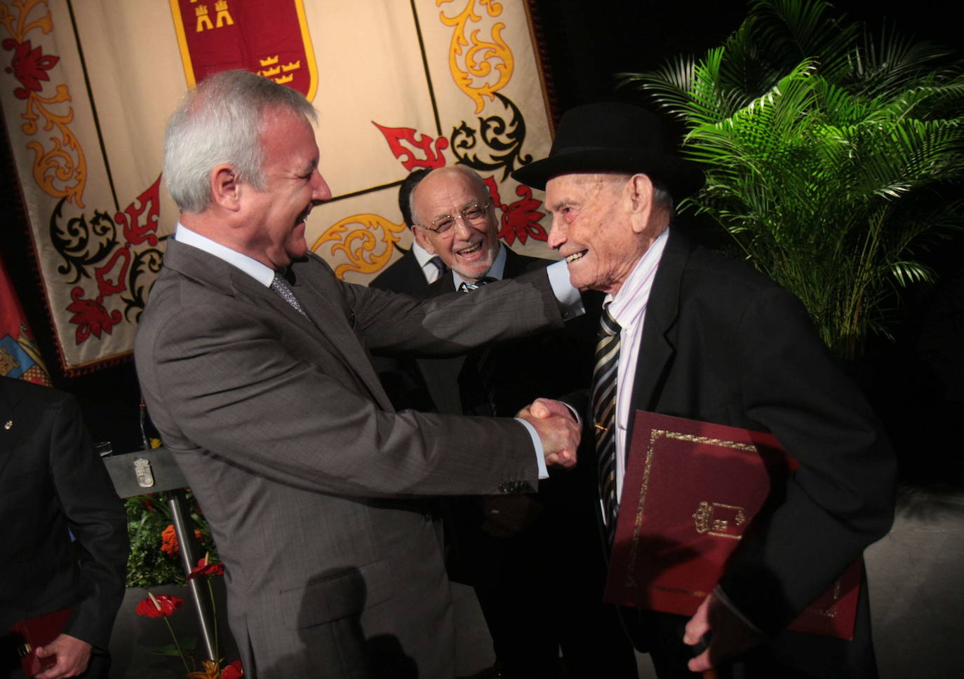 El entonces presidente regional, Ramón Luis Valcárcel, entrega el Diploma de Servicios Distinguidos a Juan Tudela, en el acto del Día de la Región celebrado en 2011.