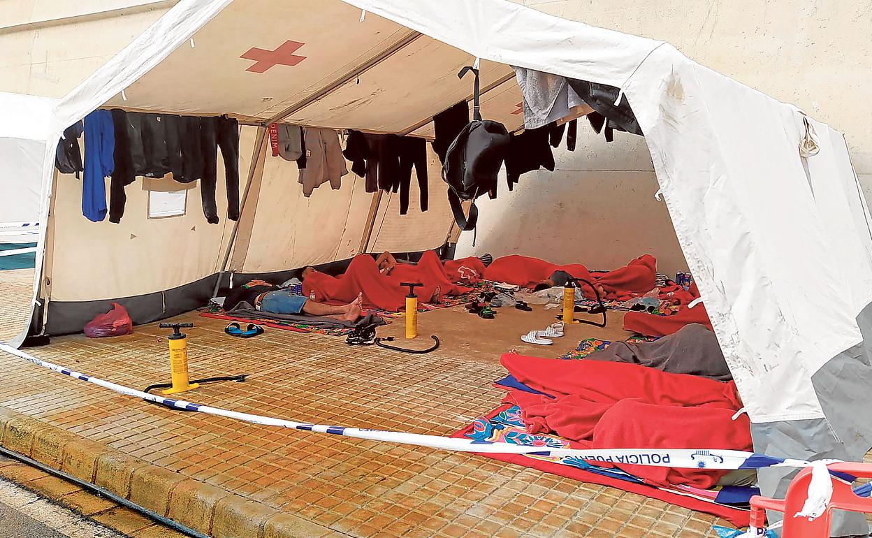 Un grupo de inmigrantes descansa en una carpa de Cruz Roja, ayer en Escombreras. 