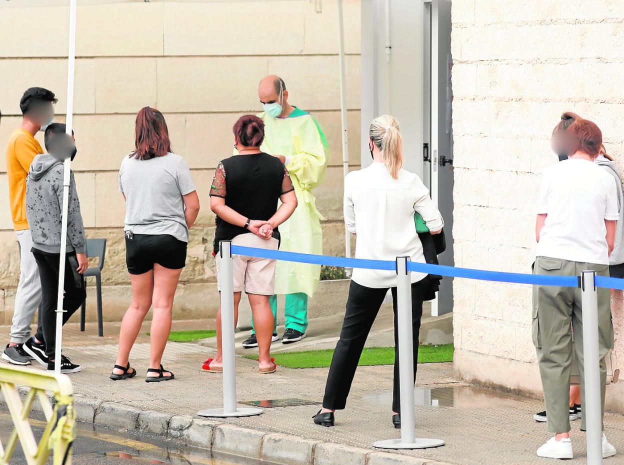 Varios ciudadanos hacen cola a las puertas del punto Covid del hospital Morales Meseguer para someterse a una prueba PCR, ayer. 