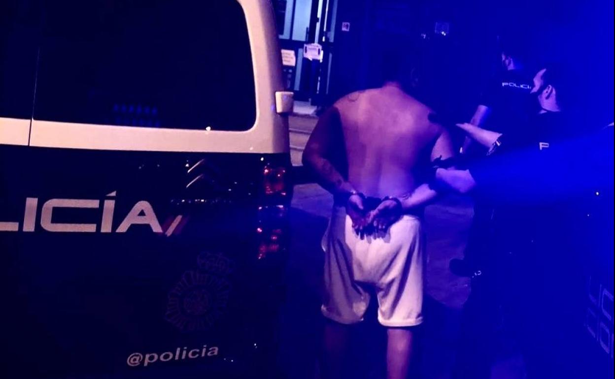 Un agente de la Policía Nacional junto al detenido.